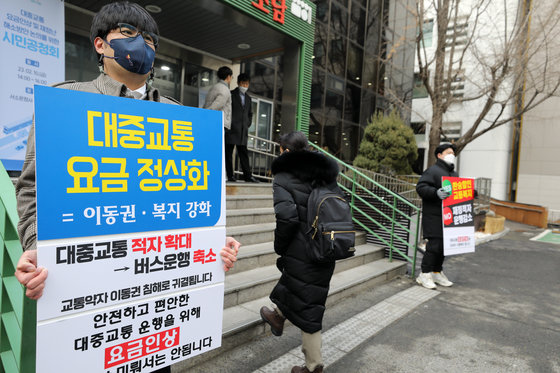 10일 오후 ‘대중교통 요금인상 및 재정난 해소방안 논의를 위한 시민공청회’가 열리는 서울 중구 서울시청 서소문청사 후생동 앞에 한 시민이 대중교통 요금 인상을 지지하는 피켓을 들고 있다. 2023.2.10/뉴스1