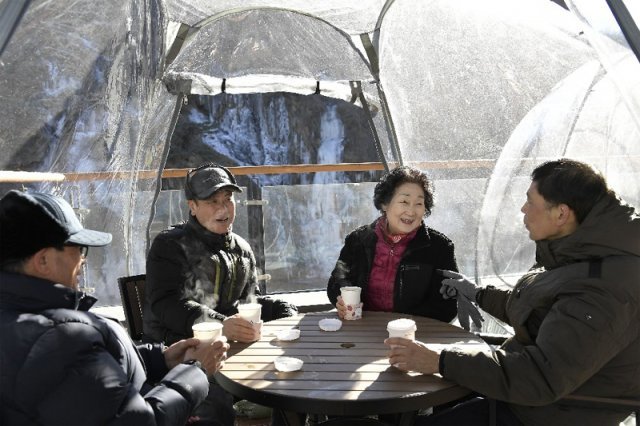 지난달 25일 서울 서대문구 홍제천 인공폭포 앞 ‘수변테라스 카페’에서 주민들이 차를 마시며 담소를 나누고 있다. 서대문구 제공