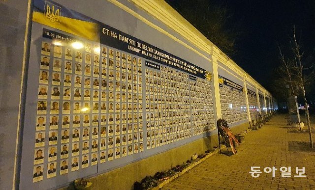 11일(현지 시간) 저녁 우크라이나 수도 키이우 중심가의 추모의 벽에 러시아의 침공으로 숨진 우크라이나인들의 사진이 벽면 전체를 가득 메우고 있다. 키이우=조은아 특파원 achim@donga.com