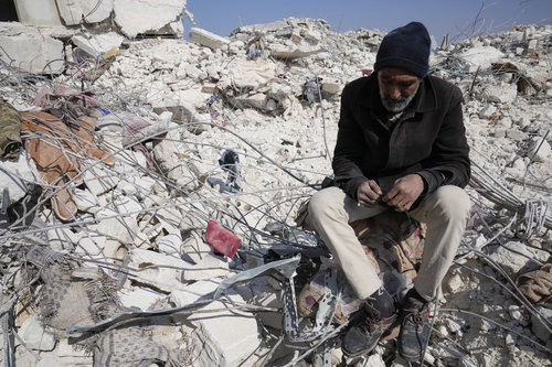 12일(현지시간) 시리아 아타렙의 지진 피해 현장에서 한 남성이 건물 잔해에 앉아있다.뉴시스