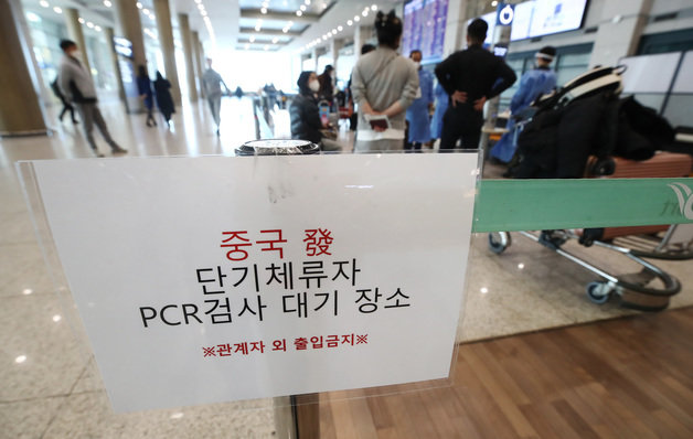 지난 8일 인천공항 제1여객터미널 입국장에서 중국발 입국자들이 방역 관계자의 안내를 기다리고 있다. 뉴스1