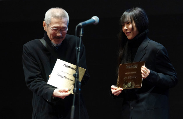 13일 오후(현지시간) 프랑스 파리 시네마테크 프랑세즈에서 열린 ‘홍상수 감독 전작 회고전’에서 개막작 ‘소설가의 영화’ 상영 전 홍상수(64) 감독과 배우 김민희(41)가 무대에 올라 인사를 하던 중 시네마테크 프랑세즈 측으로부터 각각의 이름이 새겨진 황금명패를 선물받고 있다. 2023.02.14/뉴스1