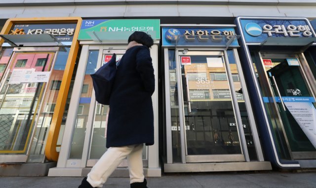 지난달 25일 서울 시내의 주요 시중은행 ATM 앞으로 한 시민이 지나가고 있다. 뉴시스