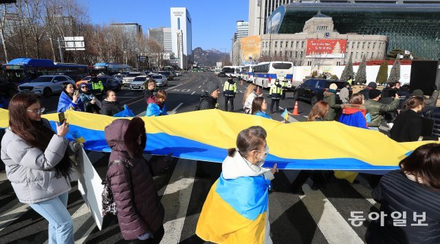 참석자들이 기자회견을 마친 후  대형 우크라이나 국기를 들고 서울광장으로 행진을 하고 있다.