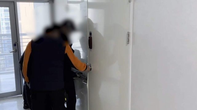 경찰관과 소방관들이 지난달 중순 해킹조직을 검거하기 위해 서울의 한 오피스텔에 마련된 은신처 문을 강제 개방하고 있다. 전남경찰청 제공