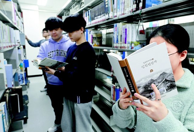 인천 남동구 미추홀도서관 2층 자료실을 찾은 시민들이 인천시가 발간한 ‘인천전쟁사’를 보고 있다. 시 홈페이지에서 파일을 무료로 내려받을 수도 있다. 인천시 제공