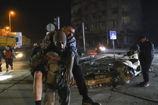 20일(현지시간) 튀르키예 하타이주에서 규모 6.4의 지진이 또다시 발생해 한 군인이 다친 남성을 업어 옮기고 있다. 2023.02.21. 안타키아=AP/뉴시스