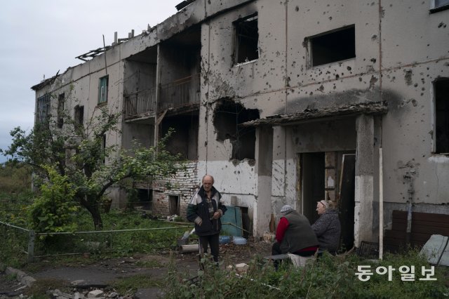 우크라이나 하르키우 남동부 흐라코베 지역의 한 포격당한 주택가 앞에 주민들이 모여 있다. 우크라이나 전쟁은 하르키우에 살던 12세 소녀 예바 스칼레츠카의 삶을 송두리째 바꿔놓았다. 흐라코베=AP 뉴시스