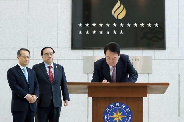 윤석열 대통령이 24일 국가정보원 청사를 찾아 2023년도 업무계획을 보고받기 전 방명록을 작성하고 있다. 왼쪽부터 김규현 국정원장, 김성한 국가안보실장, 윤 대통령. 2023.2.24. 대통령실 제공