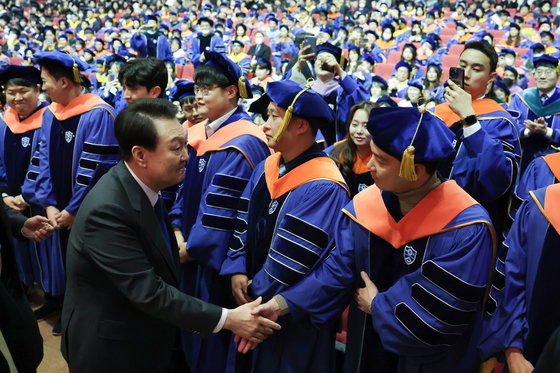 윤석열 대통령이 27일 서울 서대문구 연세대학교에서 열린 2023년 2월 학위수여식에서 졸업생들과 악수를 나누고 있다. 대통령실 제공