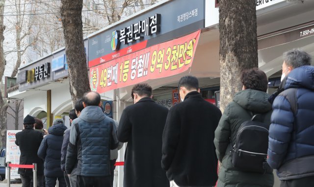 서울의 한 복권판매점 앞에 복권을 사기 위한 시민들이 길게 줄을 서 있다. 뉴스1