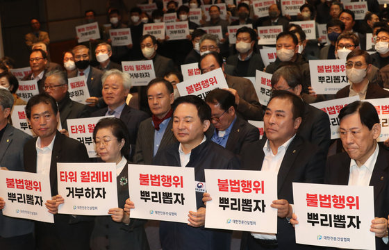 8일 서울 동작구 전문건설회관에서 열린 ‘건설현장 불법·부당행위 실태고발 증언대회’에서 참석자들이 손피켓을 들고 구호를 외치고 있다. 2023.3.8. 뉴스1