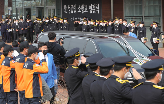 9일 전북 김제시 국립청소년농생명센터에서 열린 화재 현장 인명 구조 중 순직한 故성공일 소방교의 영결식에서 동료 소방공무원들이 운구차량을 향해 거수경례를 하고 있다.2023.3.9/뉴스1