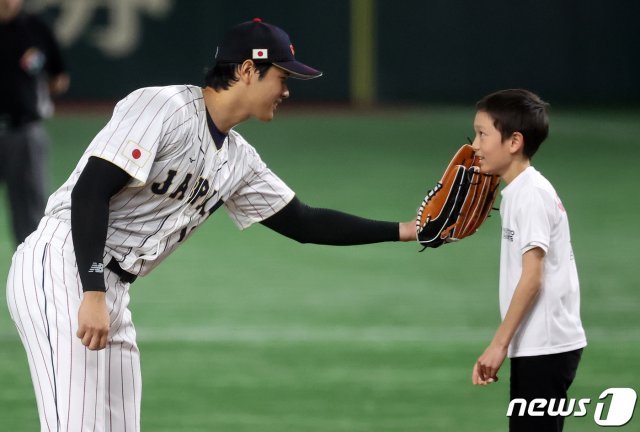 오타니가 경기 전 공을 가져단 준 소년의 얼굴을 글러브로 쓰다듬어주고 있다.   도쿄-뉴스1
