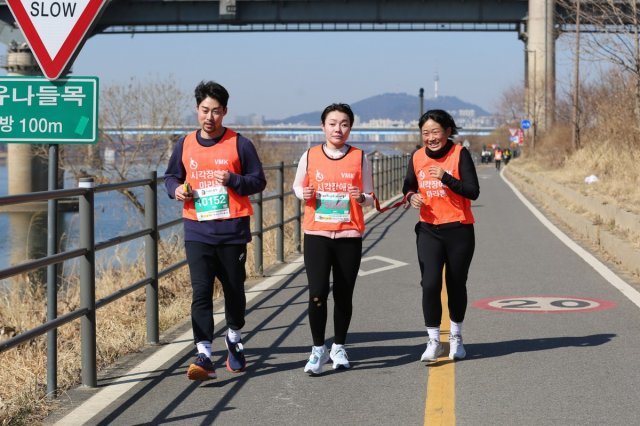 김예지 의원(가운데)이 2월 26일 열린 고구려마라톤 10km에 출전해 ‘가이드 러너’ 홍산 씨(오른쪽)와 함께 달리고 있다. 김예지 의원 제공.
