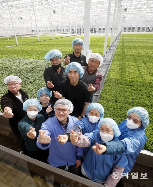 전북 무주에 자리한 스마트팜 ‘무주원’의 한경훈 대표(앞줄 오른쪽 네번째)와 직원들이 함께 ‘손하트’를 그리며 웃고 있다. 한 대표는 지역사회에서 13명을 고용하는 한편 청년 직원들에게는 사택도 제공하고 있다. 무주=박영철 기자 skyblue@donga.com