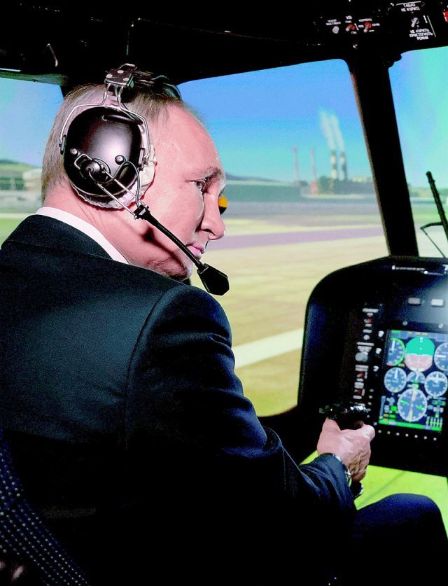 블라디미르 푸틴 러시아 대통령이 14일 울란우데 항공훈련장을 방문해 헬리콥터 시뮬레이터 앞에 앉아 시뮬레이션 조종을 해보고 있다. 울란우데=AP 뉴시스