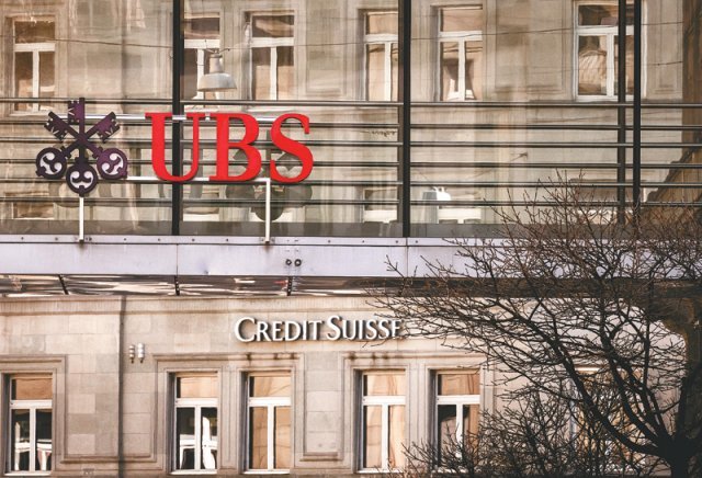 파산 위기에 놓인 스위스 업계 2위 은행 크레디트스위스(CS)와 CS인수가 임박한 것으로 알려진 업계 1위 UBS 로고가 18일(현지 시간) 스위스 취리히 두 빌딩에서 각각 보이고 있다. 취리히=AP 뉴시스