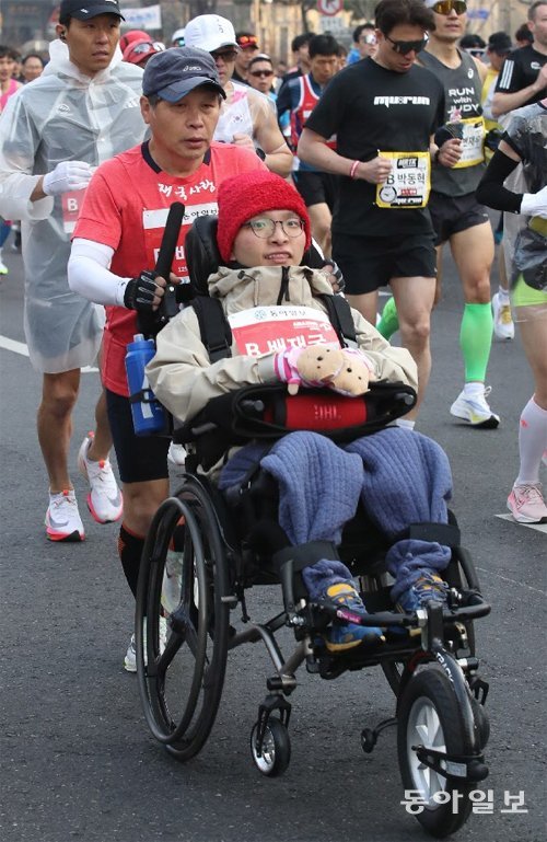 풀코스에 참가한 배종훈 씨(57)가 근육이 점차 경직되는 
희소병(근이영양증)을 앓고 있는 아들 배재국 씨(27)의 휠체어를 밀며 뛰는 모습. 박영대
 기자sannae@donga.com