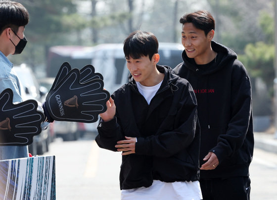 위르겐 클린스만 감독이 이끄는 대한민국 축구 국가대표팀 김문환(가운데)과 백승호가 소집 훈련을 위해 20일 오후 경기 파주트레이닝센터(NFC)에 들어서며 팬들과 하이파이브 하고 있다. 2022.3.20/뉴스1 ⓒ News1