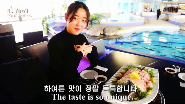 북한 유튜버 유미가 대동강수산물식당에서 철갑상어를 맛보고 있다. (출처=유튜브 Olivia Natasha- YuMi Space DPRK daily)