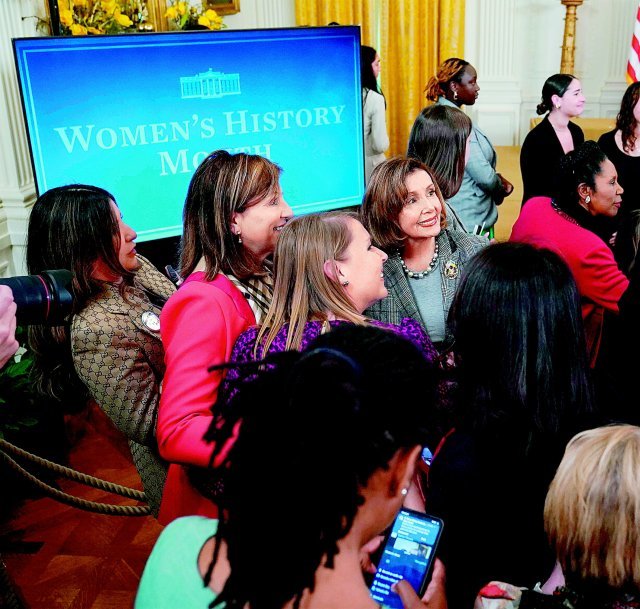 낸시 펠로시 미 하원의원(왼쪽에서 네 번째)이 22일(현지 시간) 워싱턴 백악관을 방문해 많은 여성의 사진 촬영 요청에 응하고 있다. 워싱턴=AP 뉴시스