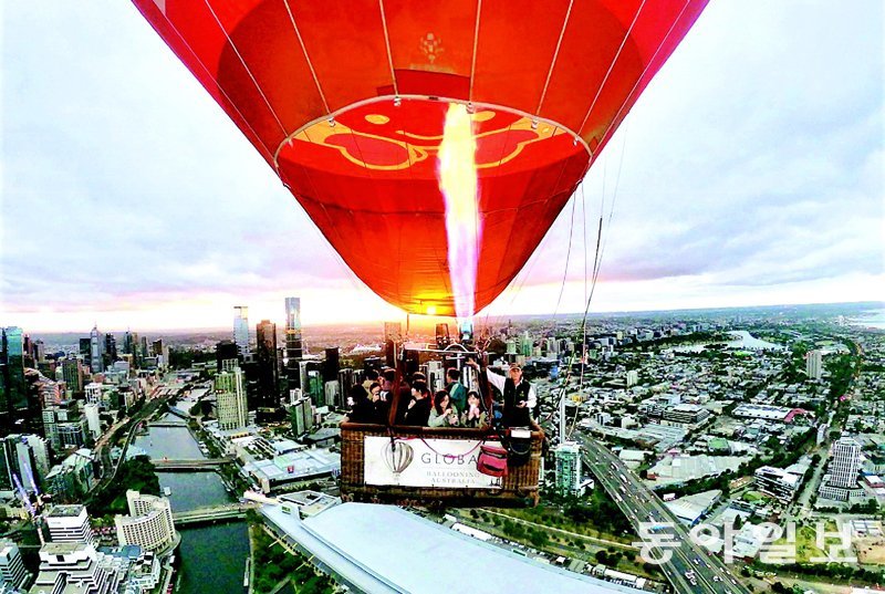 멜버른 도심 빌딩 위를 날아가는 열기구.