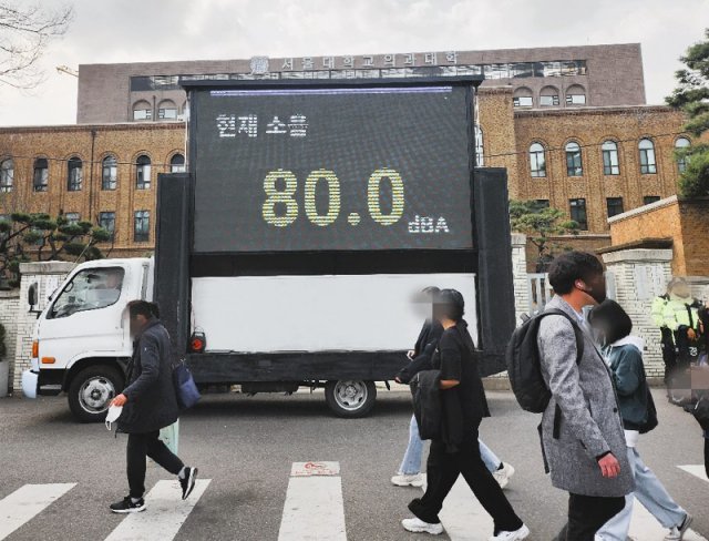경찰이 25일 오후 열린 서울 종로구 대학로 집회에서 처음 도입한 이동식 소음 전광판을 통해 현재 소음을 알려주고 있다. 뉴스1