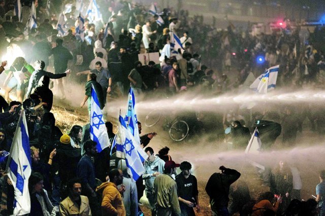 이스라엘 경찰, 시위대에 물대포 27일 이스라엘 텔아비브에서 베냐민 네타냐후 대통령의 사법부 무력화 법안 강행에 
반대하는 시위대가 도로를 점거하자 경찰이 시위대에 물대포를 쏘고 있다. 네타냐후 대통령이 하루 전 법안 강행을 공개 비판한 요아브
 갈란트 국방장관을 전격 해임한 것에 분노한 수만 명의 시민이 거리로 몰려나오자 강경 진압을 계속하고 있다. 텔아비브=AP 뉴시스