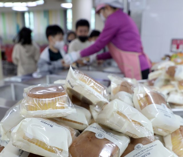 학교비정규직연대회의가 총파업에 돌입한 31일 전북 전주시 덕진구 한 초등학교에서 학생들이 대체 급식으로 빵과 음료를 받고 있다. 뉴스1