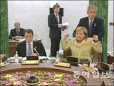 조지 W 부시 대통령이 어깨에 손을 얹자 앙겔라 메르켈 독일 총리가 깜짝 놀라는 모습. 위키피디아