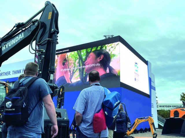 Visitors of Bauma 2022, held in Munich, Germany, watch a video wishing for Busan to host the World Expo 2030 at Hyundai Construction’s booth. Photo by HD Hyundai