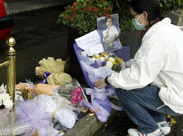 가수이자 배우인 장국영이 사망한 다음날인 2003년 4월2일, 한 팬이 센트럴 비즈니스 지구의 만다린 호텔 밖에 꽃과 메시지를 놓고 있다.ⓒ AFP=뉴스1