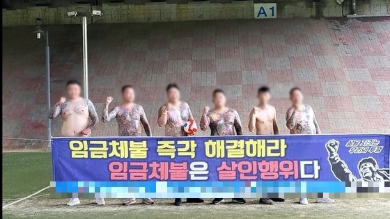 2022년 여름 노조 사무실 근처 야외에서 문신을 한 상반신을 노출하고 기념사진을 촬영한 A 씨 일당들. 경기남부경찰청 제공