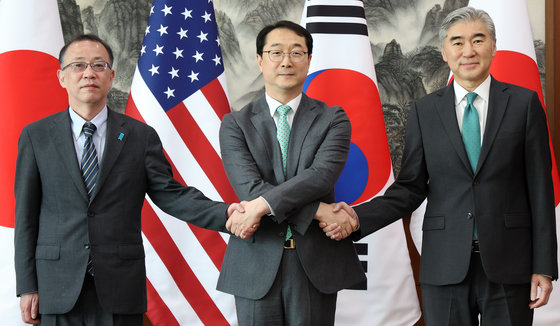 우리 측 북핵 수석대표 김건 한반도 평화 교섭본부장과 미국 측 수석대표 성 김 미 국무부 대북 특별대표, 일본 측 수석대표 후나코시 다케히로 일본 외무성 아시아·대양주 국장이 7일 오전 서울 종로구 정부서울청사 별관 외교부에서 열린 한·미·일 북핵 수석대표 협의에 앞서 손을 맞잡고 있다. 사진공동취재단