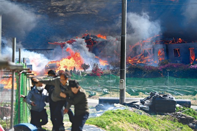 11일 오전 강원 강릉시 난곡동에서 주민들이 불타는 집을 뒤로하고 긴급히 대피하고 있다. 강원도민일보 제공