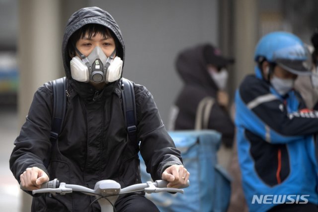 11일 중국 베이징 시내에 황사가 불어닥치자 한 주민이 호흡기를 착용한 채 자전거를 몰고 있다. 전날 밤부터 베이징을 덮친 황사와 모래폭풍으로 강풍 경보와 황사 경보가 동시에 발령됐다. 2023.04.11.베이징=AP/뉴시스