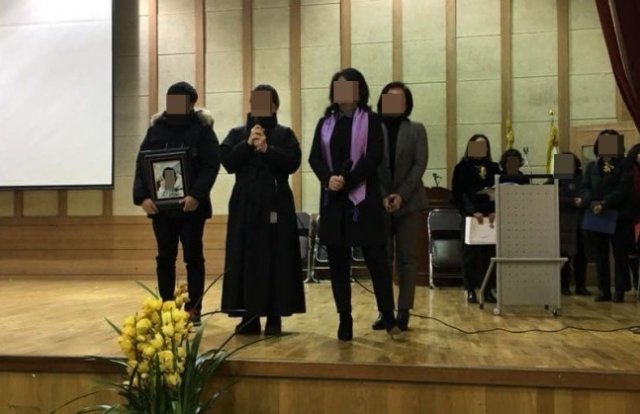 2015년 학교폭력으로 극단적 선택을 한 자녀의 영정사진을 들고 A여고 졸업식에 참석한 이기철 씨. 이기철 씨 페이스북 캡처