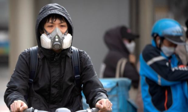 중국 베이징 시내에 황사가 불어닥치자 한 주민이 호흡기를 착용한 채 자전거를 몰고 있다. 뉴시스