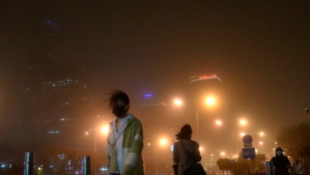 중국 베이징에서 마스크를 쓴 주민들이 모래폭풍이 불어오는 거리를 걷고 있다.