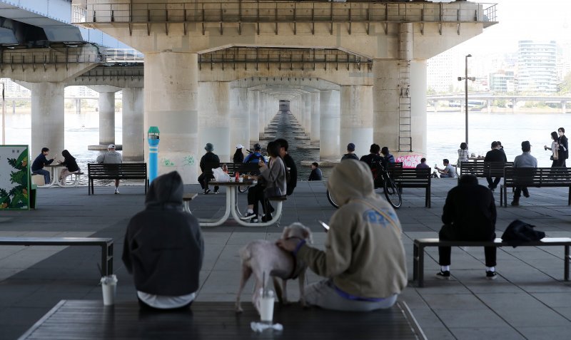 낮 최고 기온이 26도까지 오르며 초여름 날씨를 보인 19일 오후 서울 영등포구 여의도 한강공원에서 가벼운 옷차림의 시민들이 휴식을 취하고 있다. 뉴스1