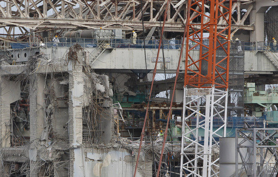 일본 후쿠시마현 제1 원자력발전소 4호기 건물 꼭대기에서 보호복과 마스크를 쓴 직원들이 일하고 있다. 2012.02.20 ⓒAFP=News1