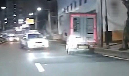 지난달 29일 새벽 부산 사하구 한 도로에서 A씨가 운전하는 탑차(오른쪽)가 맞은편에서 쫓아오는 경찰차(왼쪽)를 따돌리고 도주하고 있다.(부산경찰청 제공 영상 캡처)