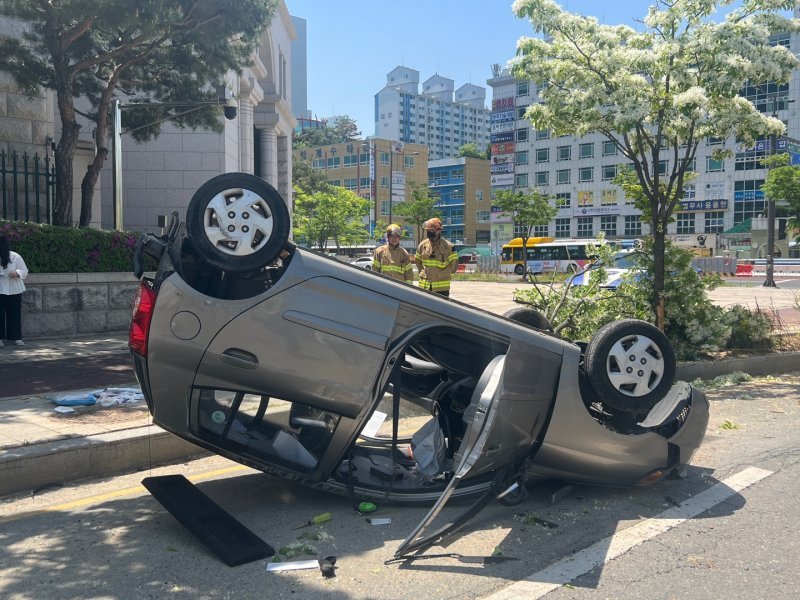 27일 오전 광주 서구 치평동 시청 앞 사거리에서 경차가 전복돼 경찰과 소방당국이 수습하고 있다. 2023.4.27. 독자제공/뉴스1