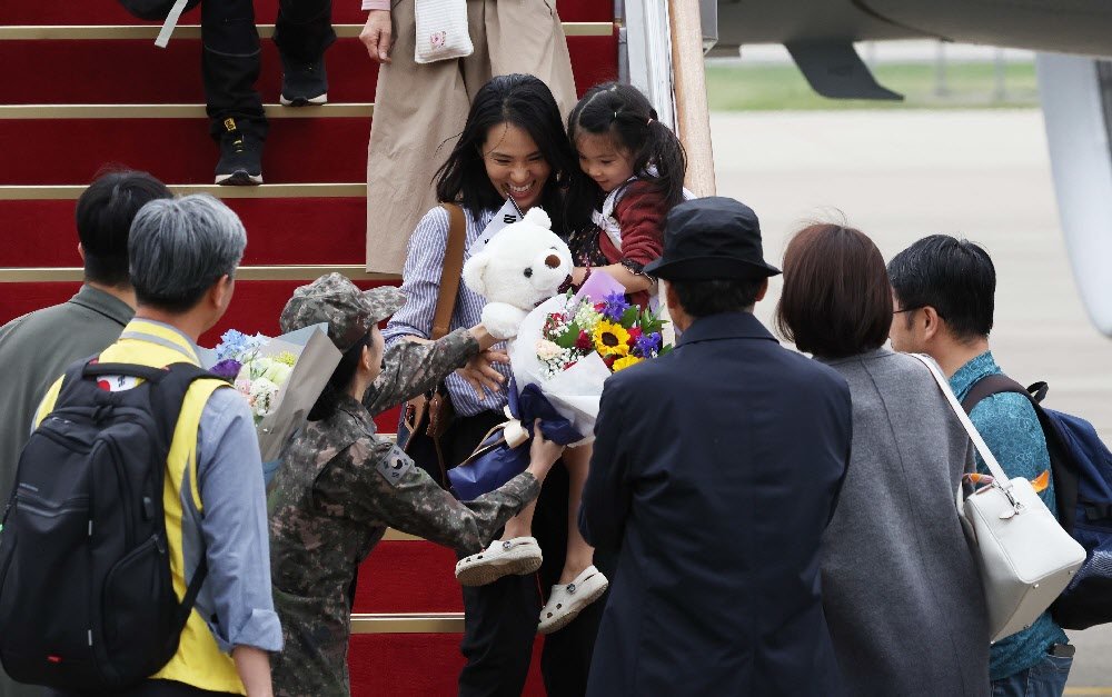 내전에 휩싸인 수단에서 탈출한 교민들이 25일 경기 성남시 서울공항에 착륙한 공군 수송기 ‘KC-330’에서 환하게 웃으며 내리고 있다. 사진공동취재단