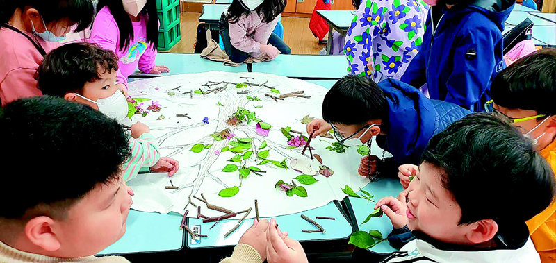 경기 부천시 고강초등학교에서 지난달 14일 열린 생태환경 기후교실에서 어린이들이 꽃과 나뭇잎, 나뭇가지 등을 이용해 나무를 꾸며 보고 있다. 부천시 제공