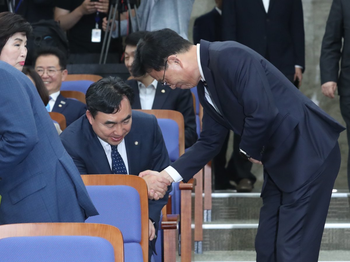 악수는 하지만… 더불어민주당 박광온 원내대표(오른쪽)가 3일 오후 국회에서 열린 의원총회에서 이날 오전 탈당 의사를 
밝힌 윤관석 의원과 악수하고 있다. 윤 의원과 이성만 의원은 2021년 전당대회 당시 ‘돈봉투 의혹’과 관련해 이날 탈당계를 
제출했다. 민주당은 이날 박 원내대표 취임 이후 첫 의원총회를 열고 쇄신안 마련에 착수했다. 뉴스1