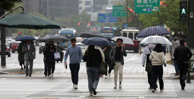 봄비가 내리는 25일 오전 서울 종로구 광화문광장에서 우산을 쓴 시민들이 발걸음을 재촉하고 있다. 2023.4.25/뉴스1