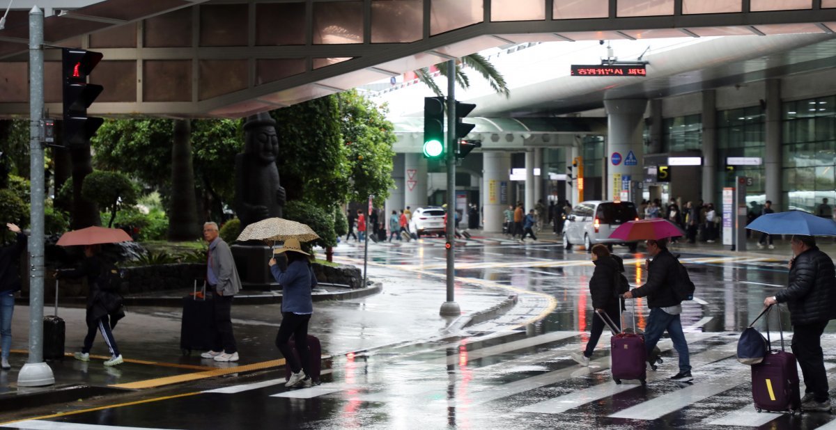 4일 관광객들이 비를 맞으며 제주국제공항 횡단보도를 건너고 있다. 뉴스1