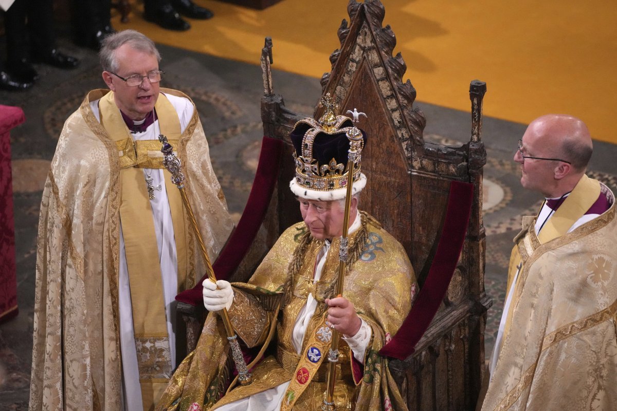 6일(현지 시간) 영국 런던 웨스트민스터 사원에서 대관식을 치른 찰스 3세 국왕(가운데)이 양옆에 성공회 사제들을 대동한 채 ‘성 에드워드 왕관’을 쓰고 앉아 있다. 런던=AP 뉴시스